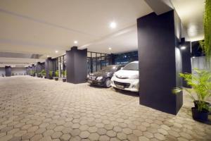 um parque de estacionamento com dois carros estacionados num edifício em DPARAGON KEBON JERUK em Jakarta