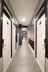 um corredor com portas e um longo corredor com azulejos em DPARAGON KEBON JERUK em Jacarta