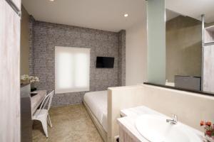 a bathroom with a bed and a sink and a television at DPARAGON KEBON JERUK in Jakarta