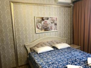 1 dormitorio con 1 cama con una foto en la pared en Vnukovo Atlantis, en Moscú