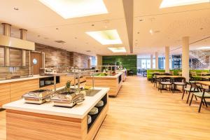a large kitchen with wooden counters and tables and chairs at TUI SUNEO Kinderresort Usedom in Trassenheide
