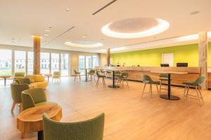 a lobby with a waiting area with chairs and tables at TUI SUNEO Kinderresort Usedom in Trassenheide