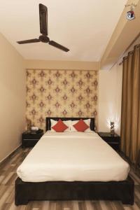 a bedroom with a large white bed with red pillows at Newest Deluxe BnB, Ranee BNB in Shillong