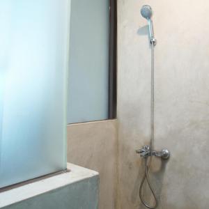 y baño con ducha y cabezal de ducha. en DPARAGON GAJAH MADA, en Yakarta