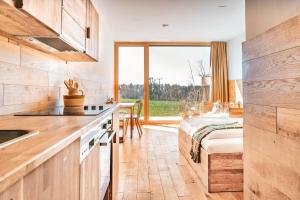 a kitchen with a sink and a bed in a room at Gut Hügle Erlebnishof & Spa in Ravensburg