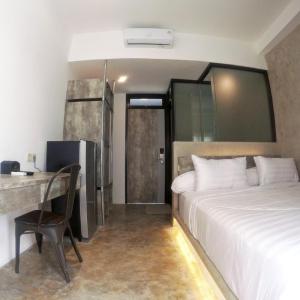 a hotel room with a bed and a desk and a bedroom at DPARAGON GAJAH MADA in Jakarta