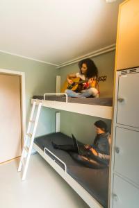 two girls sitting on a bunk bed with a laptop at Bergen Hostel Montana in Bergen