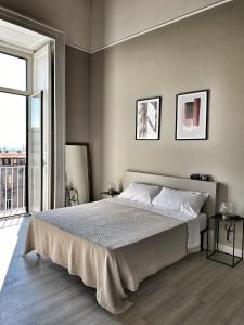 um quarto com uma cama grande e uma janela grande em Bellini View em Nápoles