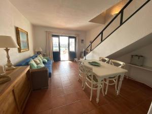 sala de estar con mesa y sofá en ATALAIA 5 by SOM Menorca, en Fornells