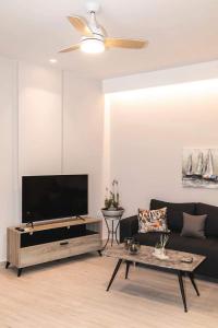 un soggiorno con divano e TV a schermo piatto di "NISSI BEACH" Houses a Città di Kos