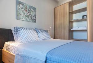 Schlafzimmer mit einem Bett mit blauer Decke in der Unterkunft "NISSI BEACH" Houses in Kos-Stadt