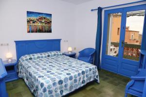 ein Schlafzimmer mit einem blauen Bett und einem Fenster in der Unterkunft Pensió Solivent in L'Escala
