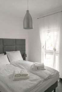 a bed with two towels on it with a window at Apartamenty na Wzgórzu in Karpacz