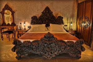 a bedroom with a large wooden bed with a wooden headboard at Eyes Of Cappadocia Cave Hotel in Uçhisar