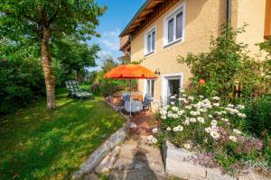 una casa con una mesa y una sombrilla en el patio en Ferienwohnungen Am Sonnenhang en Theisseil