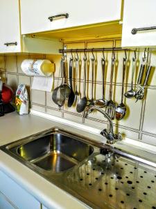 um lavatório de cozinha com utensílios pendurados na parede em Casa alla Guitgia 2 em Lampedusa
