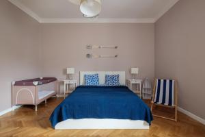 a bedroom with a blue bed and a desk at Apartamenty Starowiejska 37 in Gdynia