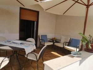 uma sala de jantar com cadeiras e uma mesa e uma mesa e uma espreguiçadeira em Casa alla Guitgia 2 em Lampedusa