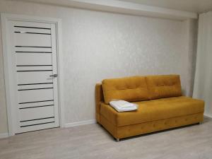 divano marrone in camera con porta di Apartments on Dubrovinskogo a Krasnoyarsk