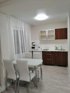 una cucina con tavolo e sedie in una stanza di Apartments on Dubrovinskogo a Krasnoyarsk