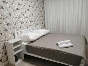 クラスノヤルスクにあるApartments on Dubrovinskogoのベッドルーム1室(ベッド1台、タオル2枚付)