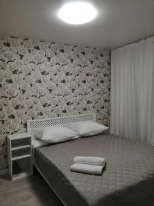 una camera da letto con un letto e asciugamani di Apartments on Dubrovinskogo a Krasnoyarsk