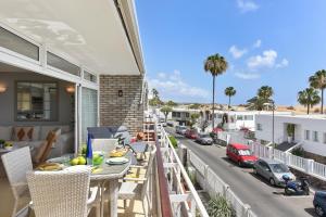 een balkon met een tafel en stoelen en een straat bij Apartment Oasis CM18 by VillaGranCanaria in Maspalomas