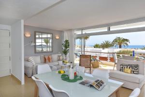 a living room with a couch and a table and chairs at Apartment Oasis CM18 by VillaGranCanaria in Maspalomas