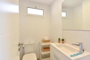 a bathroom with a sink and a toilet and a mirror at Apartment Oasis CM18 by VillaGranCanaria in Maspalomas