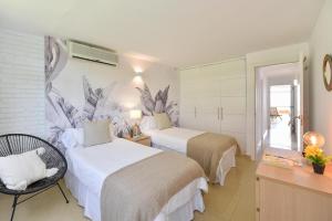 a hotel room with two beds and a desk at Apartment Oasis CM18 by VillaGranCanaria in Maspalomas