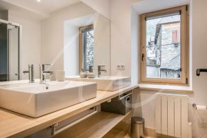 een badkamer met 2 wastafels en een grote spiegel bij Casa Montlude by SeaMount Rentals in Gessa