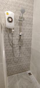 a shower with a hose attached to a wall at หอพัก ทูเอ็มเพลส 2M Place Apartment in Ban Khlong Nung