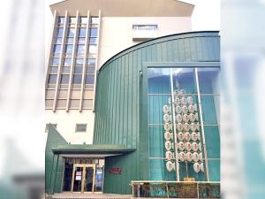 a green building with a bunch of donuts on it at Ohmachiso in Akita