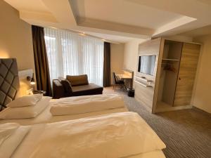 a hotel room with two beds and a television at Villa Huxori in Höxter