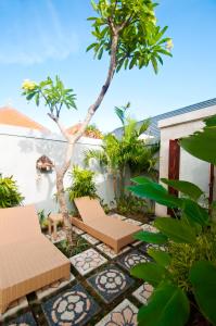 a patio with two chairs and a tree at Taman Kesari Villas in Sanur