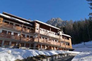 a building with snow on the ground in front of it at Wonderful Attic in Dolomite's Heart in Selva di Cadore