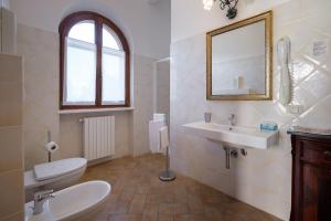 a bathroom with a toilet and a sink and a mirror at B&B Villa Giulia in Saturnia