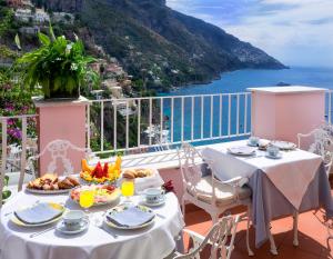 a table with food and a view of the ocean at Hotel Casa Albertina in Positano