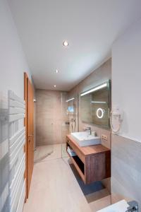 a bathroom with a sink and a mirror at MANNI home - rooms & apartments in Mayrhofen