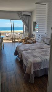 een slaapkamer met een bed en uitzicht op de oceaan bij apartamentos Vv casafaromar in Morro del Jable