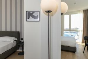 a bedroom with a bed and a lamp in a room at Hotel Punta Tipa in Trapani