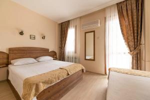 um quarto com 2 camas e uma grande janela em LİMON OTEL FOÇA em Foça