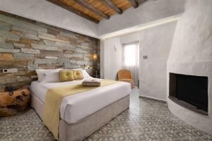 1 dormitorio con 1 cama grande y chimenea en Elakati Luxury Boutique Hotel - Adults Only en Rodas