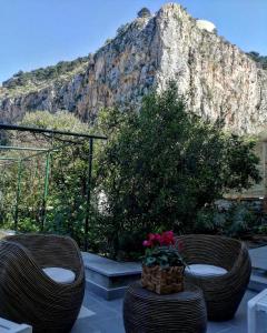 two chairs and a table with a mountain in the background at Villa Piera in Mondello