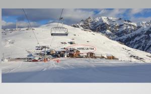 een skilift bovenop een met sneeuw bedekte berg bij Hotel La Tea in Livigno