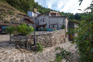 ein altes Steinhaus mit einer Steinmauer in der Unterkunft Casa Insol in Denúy