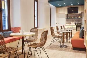 un restaurante con mesas y sillas y un bar en U-Sense Sevilla Centro, en Sevilla