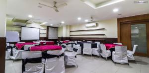 a conference room with tables and chairs and a screen at MANDAKINI PLAZA in Kānpur