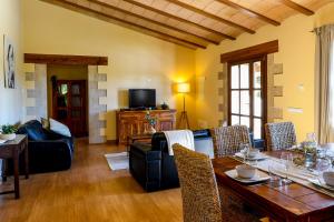 ein Wohnzimmer mit Tisch und Stühlen und einem Fernseher in der Unterkunft Moderne Finca Can Vicento - Heizung - Pizzaofen in Porto Cristo