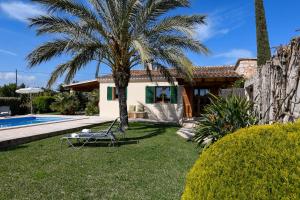 ein Haus mit einer Palme neben einem Pool in der Unterkunft Moderne Finca Can Vicento - Heizung - Pizzaofen in Porto Cristo